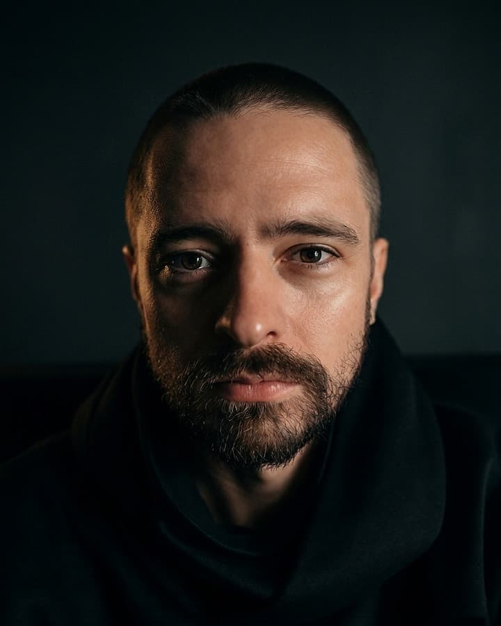 Jay Costen — editorial headshot, direct gaze, low-key lighting